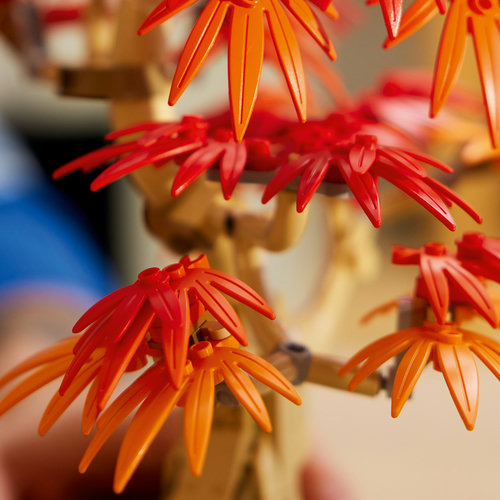 Close-up das folhas vermelhas e laranjas do LEGO Botanicals 10348 Bonsai Vermelho, textura translúcida