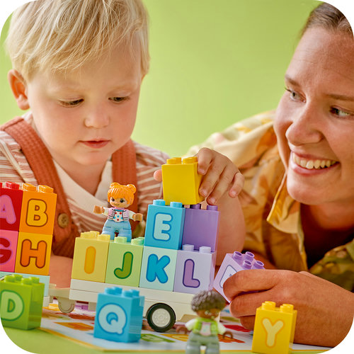 Criança montando torre de letras LEGO DUPLO com adulto por perto