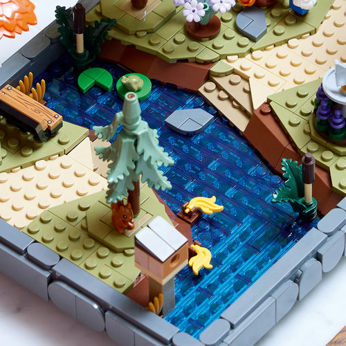 LEGO Icons 11372: vista aérea do riacho azul translúcido com sapo, esquilo, peixinhos e pedras de passagem