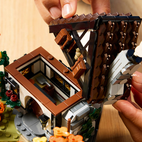 LEGO Icons 11372: pessoa removendo o telhado do chalé para acessar o interior com cozinha aconchegante