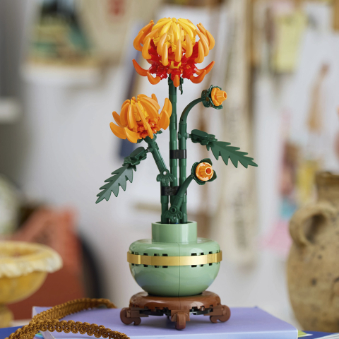 LEGO Icons Botanical 10368 Crisântemo: arranjo completo em ambiente de ateliê com vaso de cerâmica verde e base de madeira