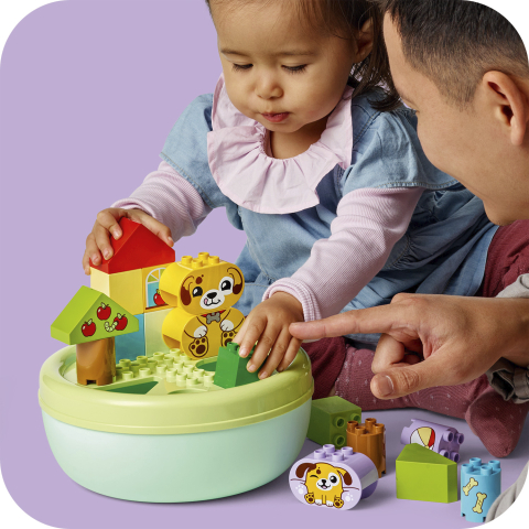 Bebê montando casinha LEGO DUPLO com pais ao redor