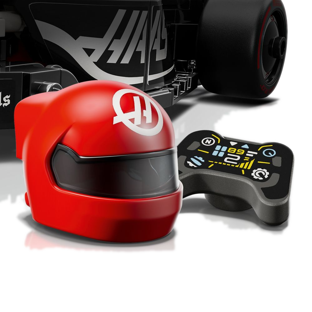Capacete vermelho HAAS e volante com mostrador impresso