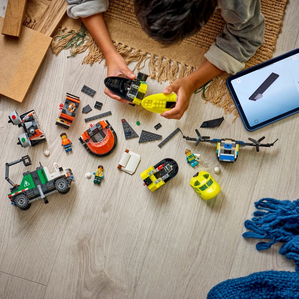 Criança brincando no chão com peças LEGO City 60505 espalhadas e tablet com manual digital