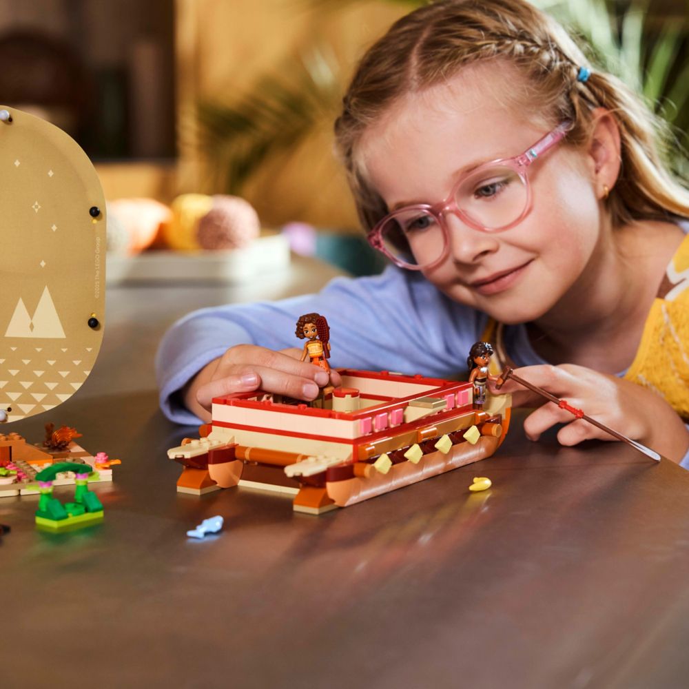 Criança brincando com a canoa LEGO Moana sobre uma mesa