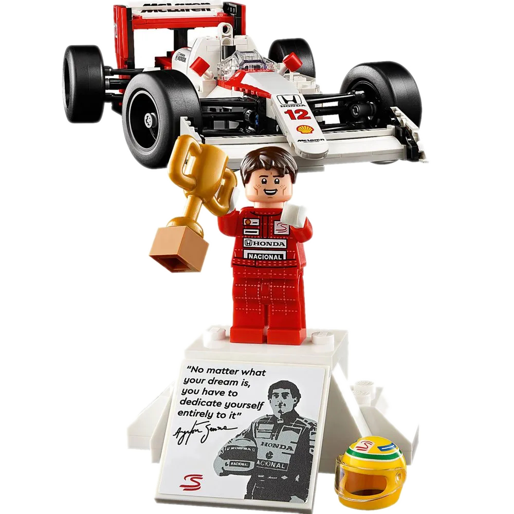 Minifigura do Ayrton Senna LEGO 10330 com troféu dourado, base com sua frase 'No matter what your dream is...' e capacete amarelo+verde icônico