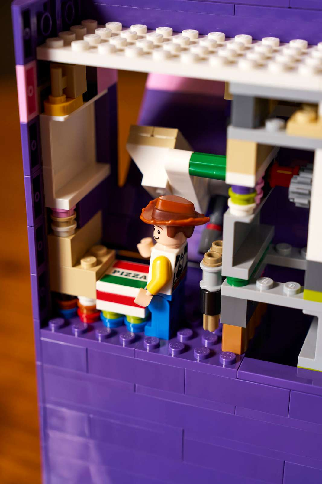 Woody minifigure escondido dentro do compartimento do livro Knick Knack com caixa de pizza listrada