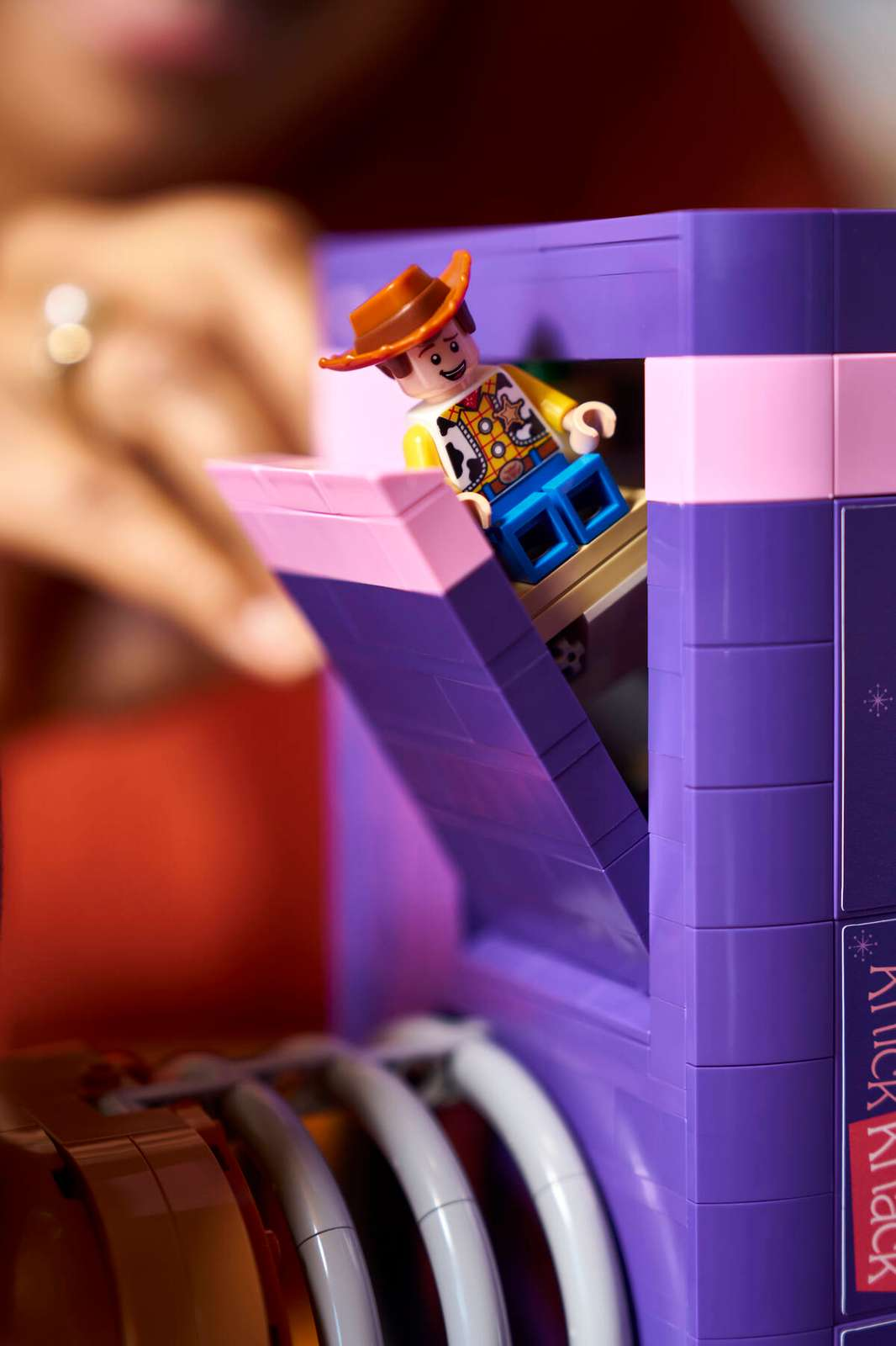 Woody emergindo do topo do livro Knick Knack com a fivela e o colete de vaca visíveis