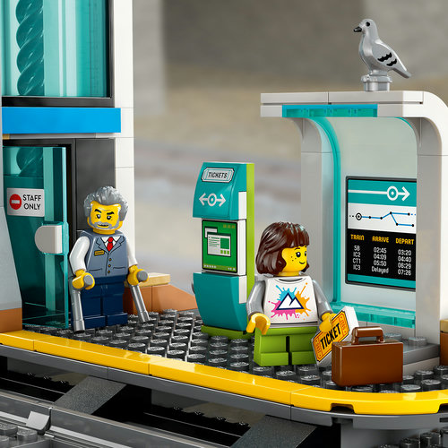 Close-up da plataforma LEGO 60469: chefe de estação, viajante com mala, máquina de bilhetes verde, monitor de horários e pombo